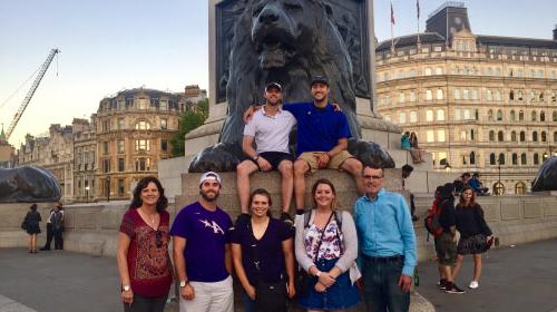 Students abroad in front of statue of a lion